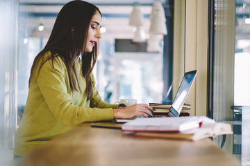 Concentrated female content manager of popular informational web site checking email box to answer...