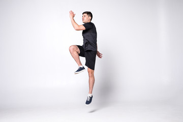 Happy young fitness man jumping isolated on a white background