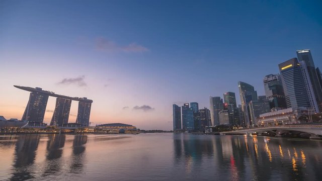 Singapore time lapse 4K, city skyline night to day sunrise timelapse at Marina Bay waterfront business district