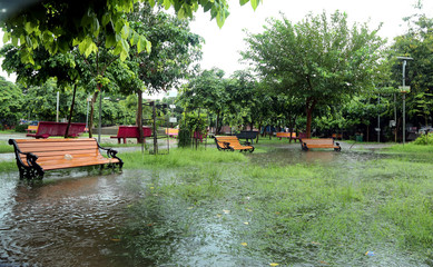 Public park drenched in rain. Water logged park.Wet benches. Park filled with water after rain.Empty park after heavy rain.