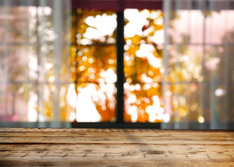 Empty wooden table near window on sunny autumn day