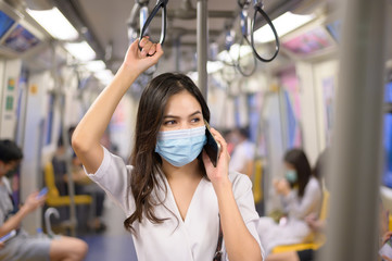 An young woman is wearing protective mask in metro , covid-19 protection , safety travel , new normal , social distancing , safety transportation , travel under pandemic concept .