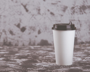 Working on the go. Coffee cup on grey stone table. Copy space