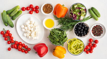 ingredients for summer vegetable salad with feta cheese and mustard on light concrete background.