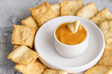 Almogrote, famous La Gomera cheese paste, in white ceramic bowl  with crusty crackers on background. Its popular appetizer served in many restaurants in Canary Islands