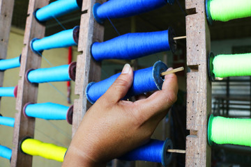 A Handloom Weaver preparing yarns in India.	