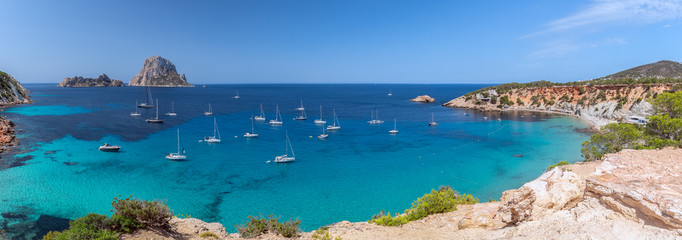 Panorama of Cala Hort with sea sailing yachts and the mountain Es Vedra. Ibiza, Balearic Islands, Spain