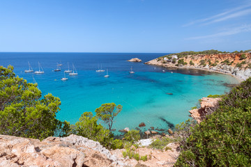 Fototapeta na wymiar Beautiful Panorama of bay Cala Hort with sea sailing yachts. Ibiza, Balearic Islands, Spain