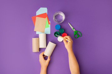 Boy makes Halloween toys from paper. toilet roll tube by hands. Creative DIY for kids on...