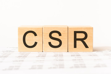 Word CSR. Wooden small cubes with letters isolated on white background with copy space available