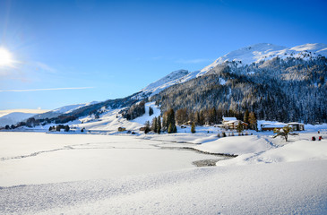 Landscape of lake Davos, covered by ice, in winter resort Davos, Switzerland.