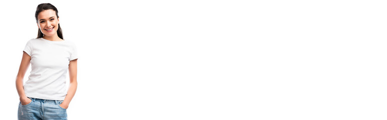 Fototapeta premium panoramic shot of young woman in white t-shirt standing with hands in pockets isolated on white