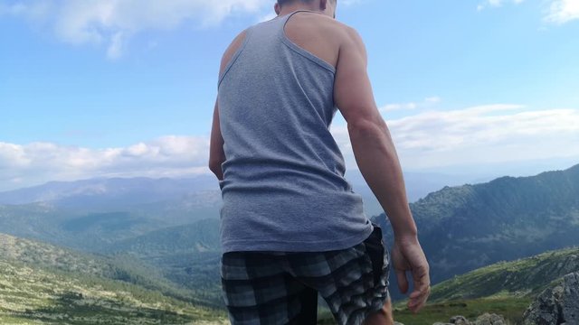 man stands on top of a mountain with open hands. at the top of the mountain, a man with his arms spread wide.