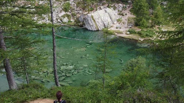 Italy  Piedmont,  Devero village  , ( lago delle streghe )  Alps - caucasian girl do trekking , hiking in a wood mountains, 
Lake of witches  with clear water in a wild landscape of nature