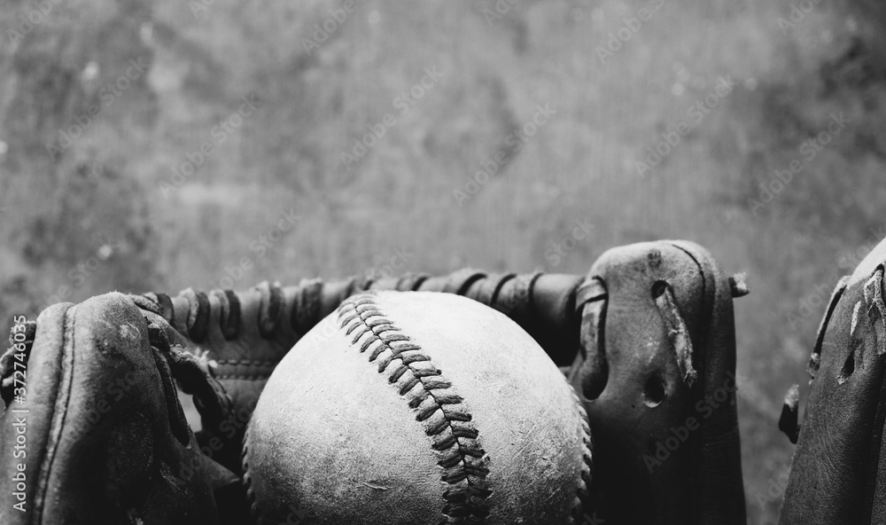 Poster old baseball glove with ball close up in black and white, old blurred texture background with copy s - Posters