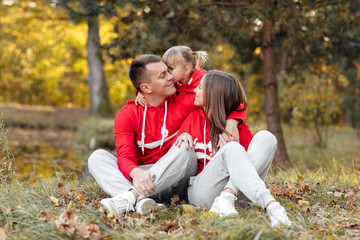 dad, mom and little cute daughter having fun and playing in the autumn park. family concept, father's, mother's and baby's day