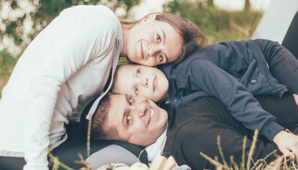 Family in tracksuits lies on the grass near the tent