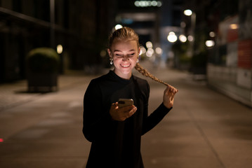 Lachende Junge Frau mit einem Smartphone in der Hand (Iphone 11 Pro) Lachende junge Frau mit einem...