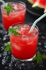 Summer cold drink with watermelon and mint on a black wooden background.