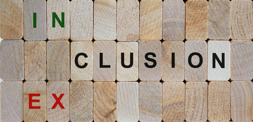 Wooden blocks form the words 'inclusion, exclusion'. Beautiful wooden background. Concept image.