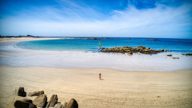 vue a&eacute;rienne prise en drone, plage de roscoff, les amiets, &eacute;t&eacute; 2020 en bretagne (france). une femme regarde son t&eacute;l&eacute;phone, un bateau &agrave; l'horizon, plage vide