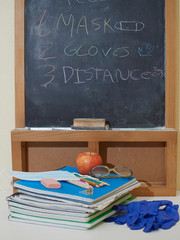 back to school with colored pencils on yellow background and coronavirus mask