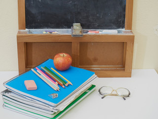 back to school with colored pencils on yellow background and coronavirus mask