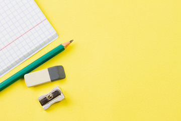 Blank notebook with a pencil on a yellow background. Place for your text. View from above. Education concept.