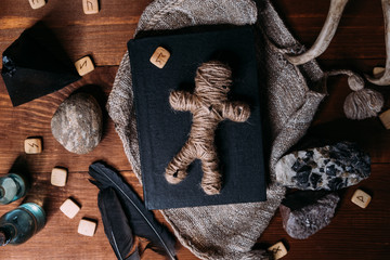 A voodoo doll made of rope lies on a black book