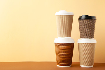 Many brown cups of coffee on beige background.