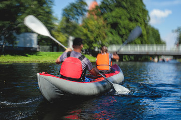 A process of kayaking in the city river canals, with colorful canoe kayak boat paddling, process of canoeing, group of kayaks
