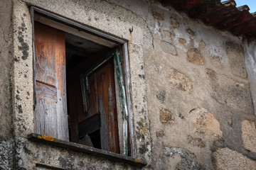 Fototapeta na wymiar Weathered And Derelict Window On Stone Wall, Braga, Portugal
