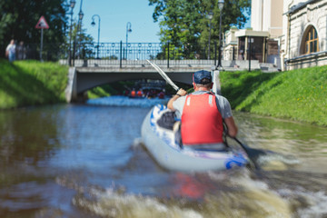 A process of kayaking in the city river canals, with colorful canoe kayak boat paddling, process of canoeing, group of kayaks