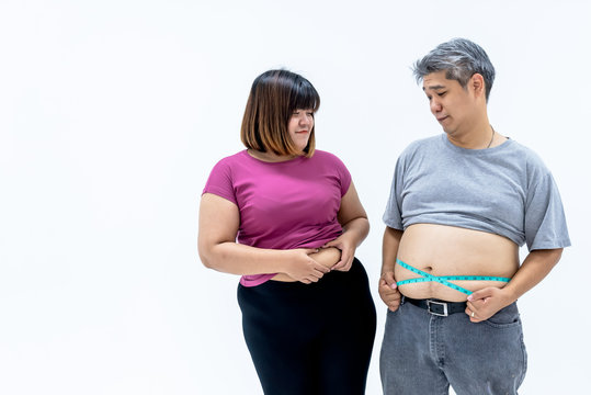 Portrait images of Asian couple, fat man and woman, are looking at each other's beelly fat, On white background, to fat people and health care concept.