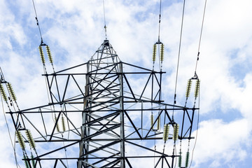 High voltage transmission lines over blue cloudy sky background. electricity pylons, cables and fencing on the tower. technologies related to Electricity, concept, Close up
