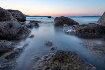 Obraz premium Photographing the waves that hit the rocks in a stormy weather with a long exposure