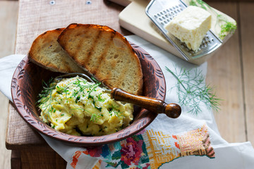 Traditional Moldavian or Romanian dish omelet with cheese, served with bread on a wooden surface. Rustic style.