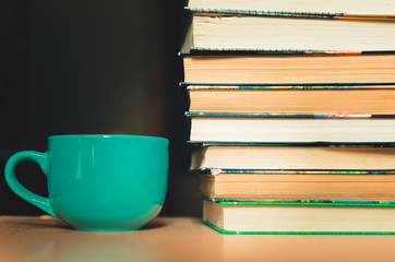 cup of coffee stand next to a stack of books
