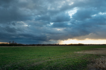 Fototapeta premium Dark rainy cloud over a green meadow
