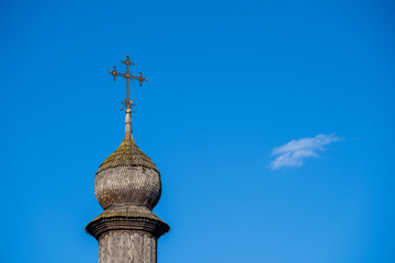 Wooden dome with orthodox cross of ancient ukrainian church against the blue sky in Kyiv, Ukraine