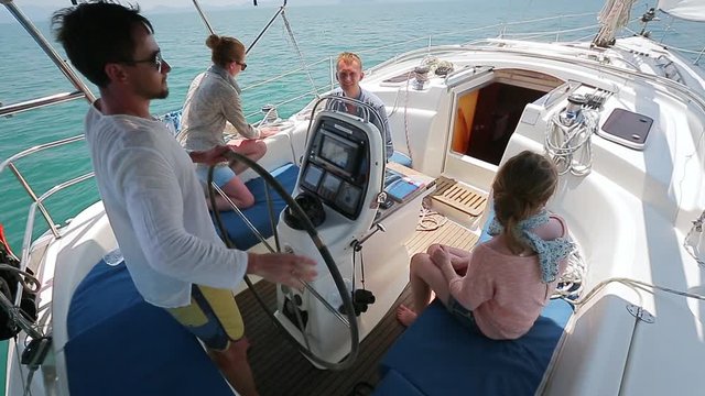 Friends sailing. Four friends sailing the boat in the tropics and relax in the cockpit