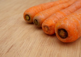 Carrots on wooden background. Organic food concept. Selective focus.
