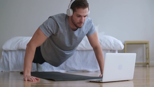 Family fitness at home, Father coach, Sports kid, Fun gymnastics. Man using laptop during online sports training