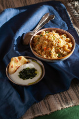 South Indian breakfast savory vegetable semolina porridge Rava Upma with green mint chutney and paratha.Authentic vegetarian food still life.