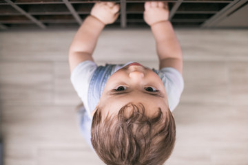 Fototapeta premium Baby is crawling around the house and playing and discovering his home playing with his toys 