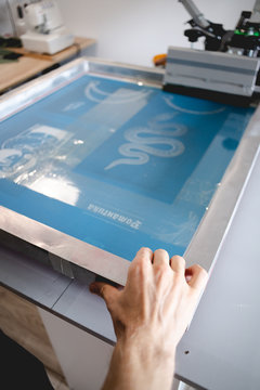 Cropped View Of Artisan Holding Frame Of Screen Printing Machine In Designer Studio