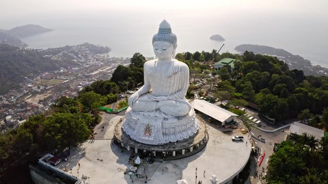 drone rising at big buddha statue, revealing phuket, aerial view