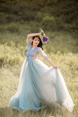 Fototapeta premium beautiful young female with makeup and hairstyle in a gentle dress in summer