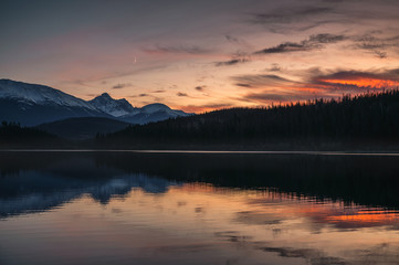 Patricia Lake with mountain range and the moon reflection at sunset