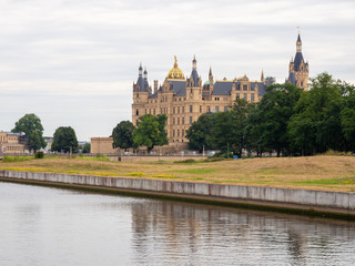 Fototapeta na wymiar Schwerin castle in summer with overcast sky and calm water